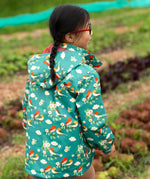 Back of a child wearing the Little Green Radicals turquoise birds recycled waterproof kids raincoat. Repeat pattern featuring bird on blossom branches.