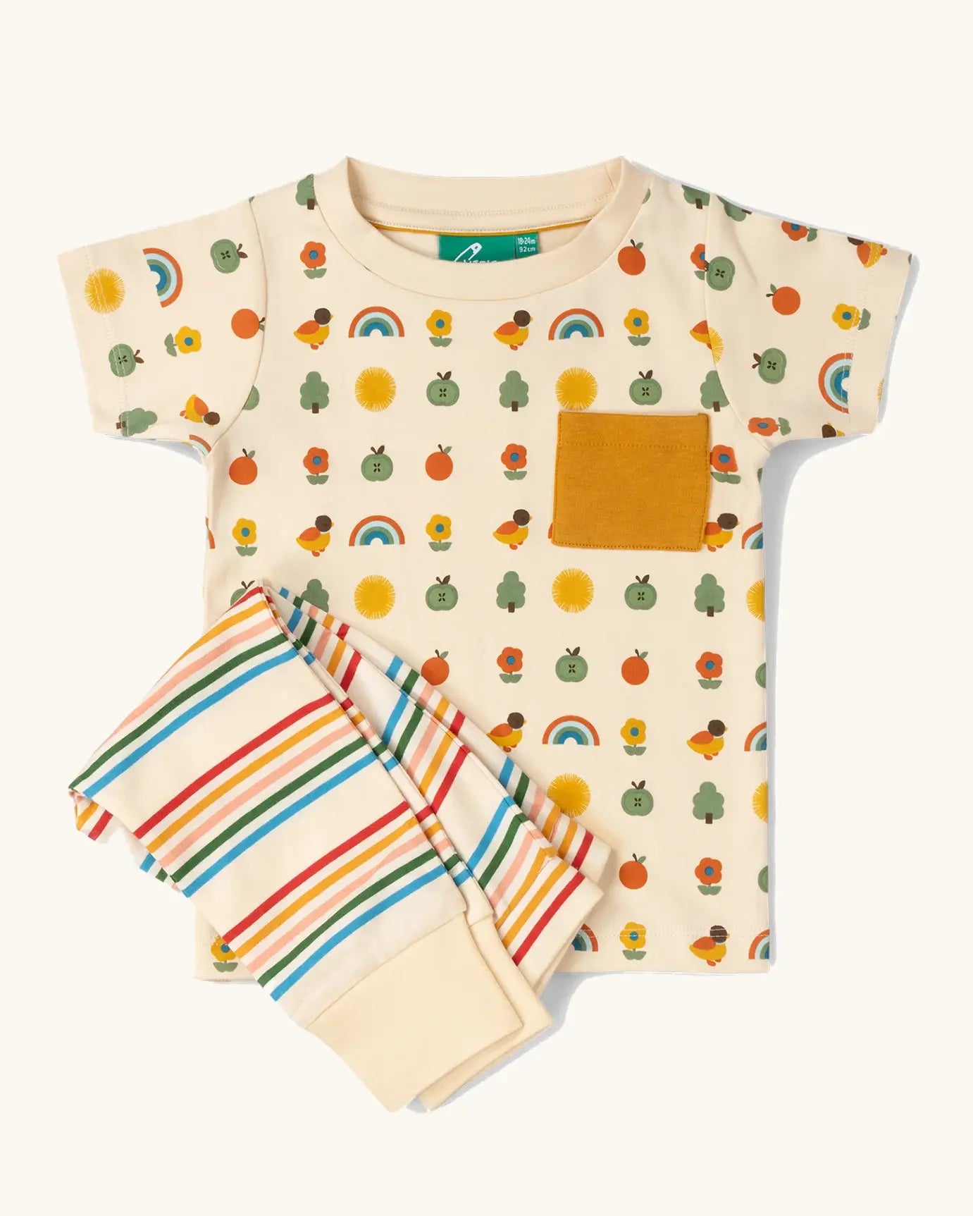 Little Green Radicals vintage style rainbows organic cotton t-shirt & jogger playset. A repeat pattern top featuring nature themed illustrations with cream rainbow striped trousers.