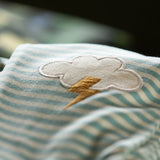 Close up of the applique cloud with bolt of yellow thunder on the Little Green Radicals weather knee patch blue and cream striped organic cotton joggers.