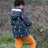Child wearing a Little Green Radicals woodland world green recycled waterproof adventure winter coat with yellow gold trousers. View of the back showing the lined hood.