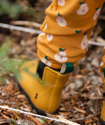 Close up of the bottoms of the Little Green Radicals yellow gold comfy organic cotton kids joggers being worn with yellow wellington boots.