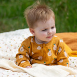 Little Green Radicals zip organic cotton footed babygrow with summer pears repeat print on a baby.