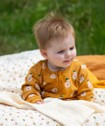 Little Green Radicals zip organic cotton footed babygrow with summer pears repeat print on a baby.