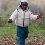 Child wearing the fleece jacket layer from the Little Green Radicals  yellow gold recycled waterproof 3 in 1 coat with blue corduroy trousers.