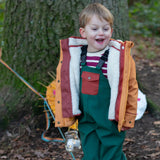 Child wearing a Little Green Radicals  yellow gold recycled waterproof 3 in 1 coat with green waterproof dungarees.