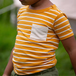 A close up of a child wearing the yellow gold striped Little Green Radicals from the Blue Organic T-Shirt Set.