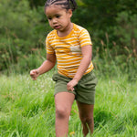 A child wearing the yellow gold striped Little Green Radicals from the Blue Organic T-Shirt Set.