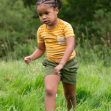 A child wearing the yellow gold striped Little Green Radicals from the Blue Organic T-Shirt Set.