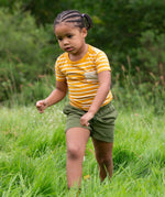A child wearing the yellow gold striped Little Green Radicals from the Blue Organic T-Shirt Set.
