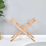 Little Green Sheep Moses Basket Stand pictured in a room with a grey coloured wall