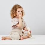 A child sitting on a Little Green Sheep Organic Single Jersey Fitted Sheet