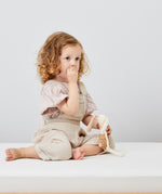 A child sitting on a Little Green Sheep Organic Single Jersey Fitted Sheet