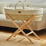 Little Green Sheep Organic Knitted Moses Basket & Mattress in linen pictured with optional folding stand