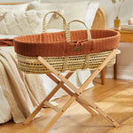 Little Green Sheep Organic Knitted Moses Basket & Mattress in terracotta orange on a folding stand which is available separately 