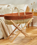 Little Green Sheep Organic Knitted Moses Basket & Mattress in terracotta orange on a folding stand which is available separately 