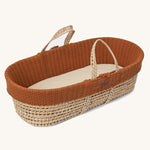 Little Green Sheep Organic Knitted Moses Basket & Mattress in terracotta pictured on a plain background