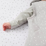 A close up of the popper closure underneath the baby's arm on the dove rice print 2.5 tog baby sleeping bag