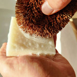 Person using a LoofCo Lime scented Washing-Up Dish Soap Bar with a coconut dish brush