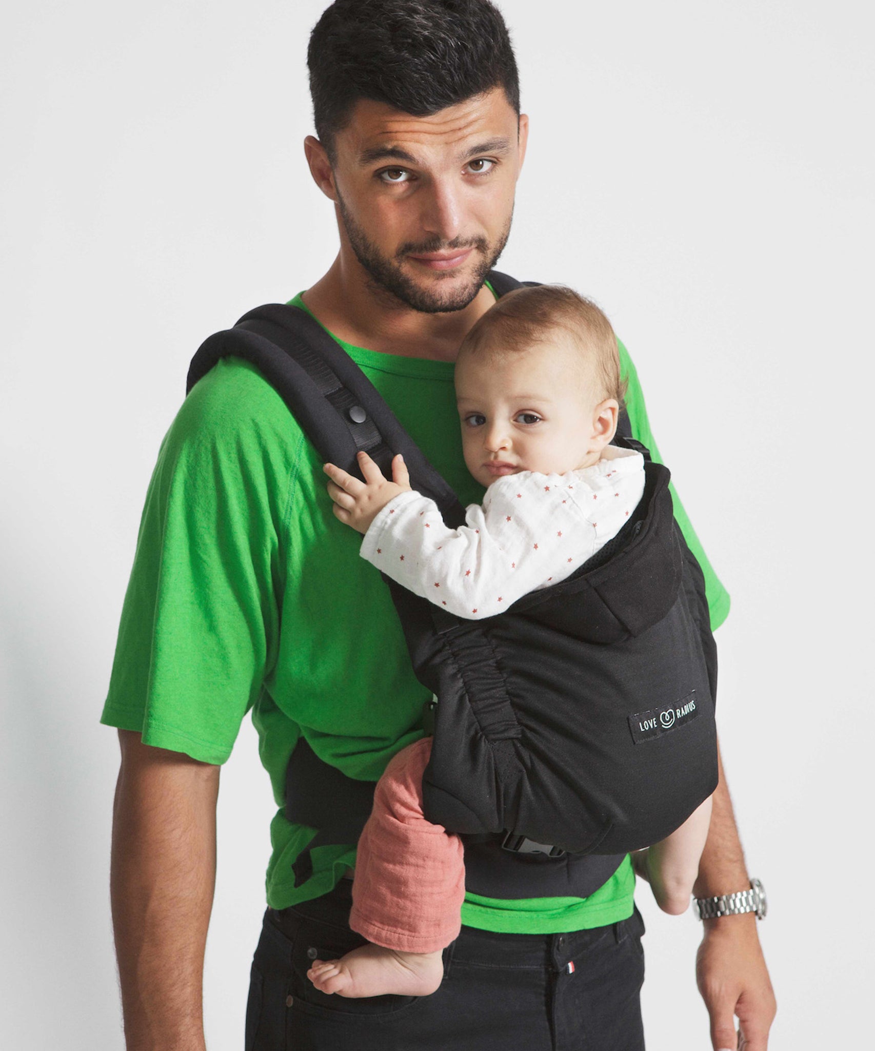 An adult carrying a baby in the Love Radius HoodieCarrier 2 - Black Forest. 