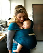 Adult carrying a baby in the Love Radius Organic Baby Wrap in Retro Blue. 