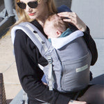 An adult carrying a baby in the Love Radius PhysioCarrier in Elephant.