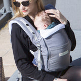 An adult carrying a baby in the Love Radius PhysioCarrier in Elephant.