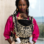 An adult carrying a baby in the Love Radius HoodieCarrier 2 - Leozebra. 