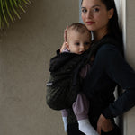 An adult carrying a baby in the Love Radius HoodieCarrier 2 - Wild Camo. 