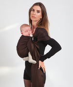 A parent wearing their baby in a espresso brown coloured Love Radius No Knot Woven Wrap. A wide range of baby wraps and carriers are available at Babipur. 
