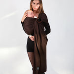 A parent wearing their baby in a espresso brown coloured Love Radius No Knot Woven Wrap. A wide range of baby wraps and carriers are available at Babipur. 