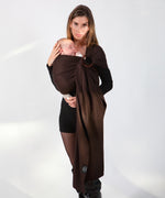 A parent wearing their baby in a espresso brown coloured Love Radius No Knot Woven Wrap. A wide range of baby wraps and carriers are available at Babipur. 