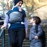 Adult carrying a baby in the Love Radius Original JPMBB Baby Wrap - peacock blue/elephant