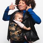 An adult carrying a baby in the Love Radius PhysioCarrier in Tiger.