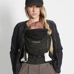 An adult carrying a baby in the Love Radius HoodieCarrier 2 - Wild Camo. 