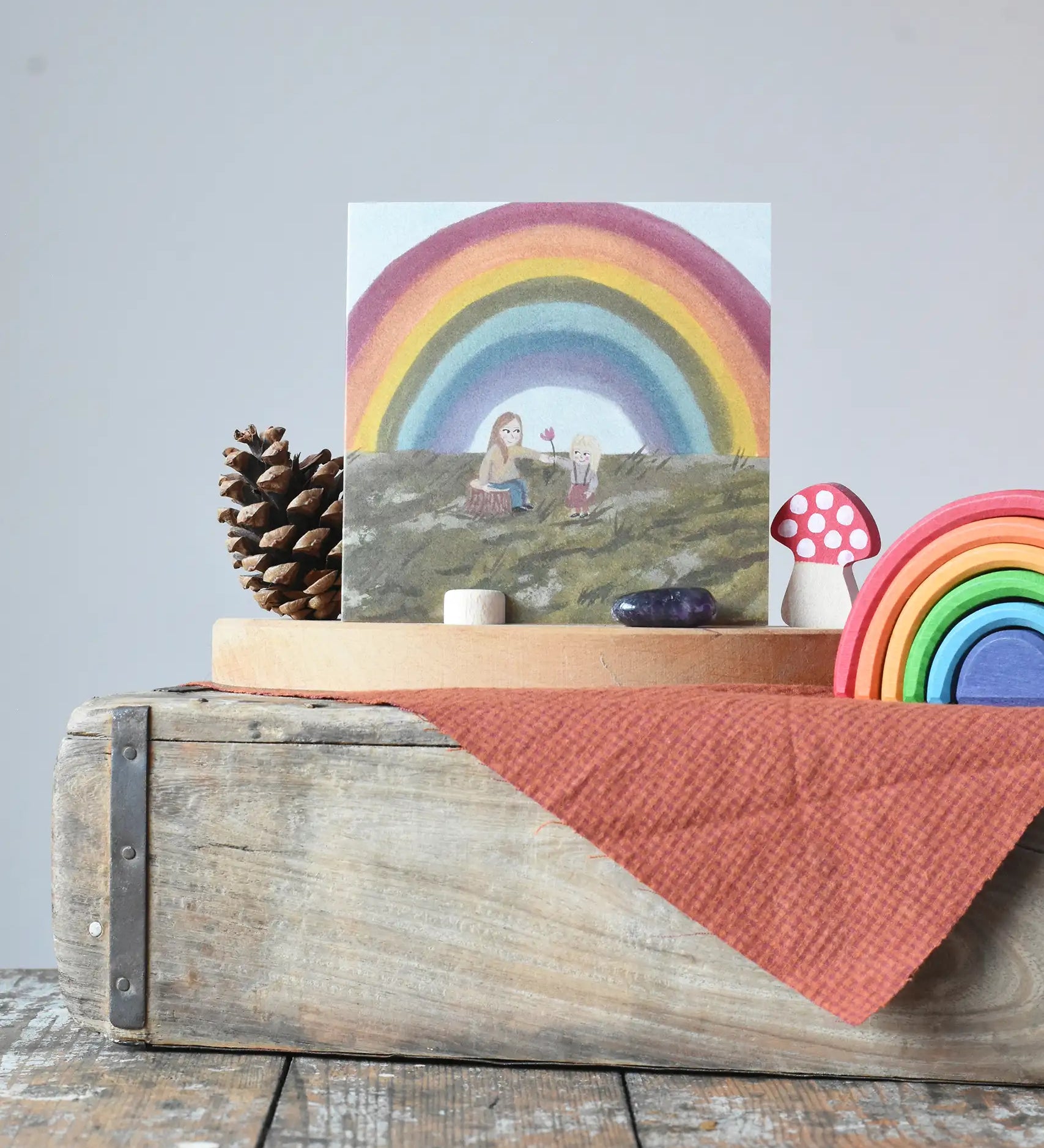 LydiaMae under the rainbow greetings card placed in a photo holder on the Grimm's celebration ring next to a mini Grimm's rainbow.