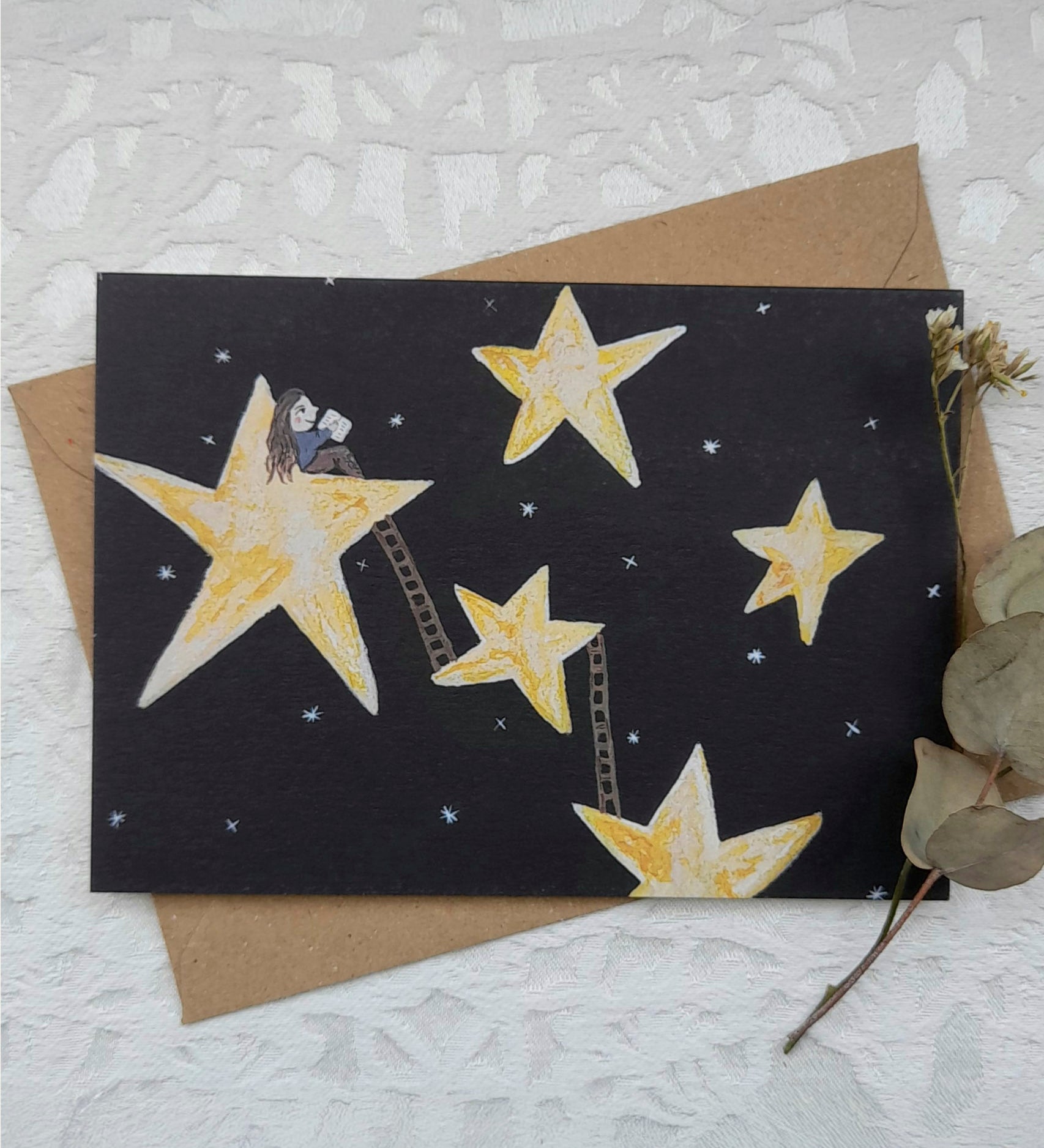 Star reader greetings card from Lydiamae showing a illustration of a starry night in a crayon drawing style. Card is on top of a brown envelope