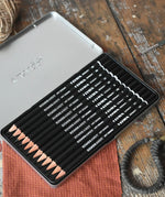 Lyra 12 drawing pencils in sizes from 6B to 4H in a metal storage tin.