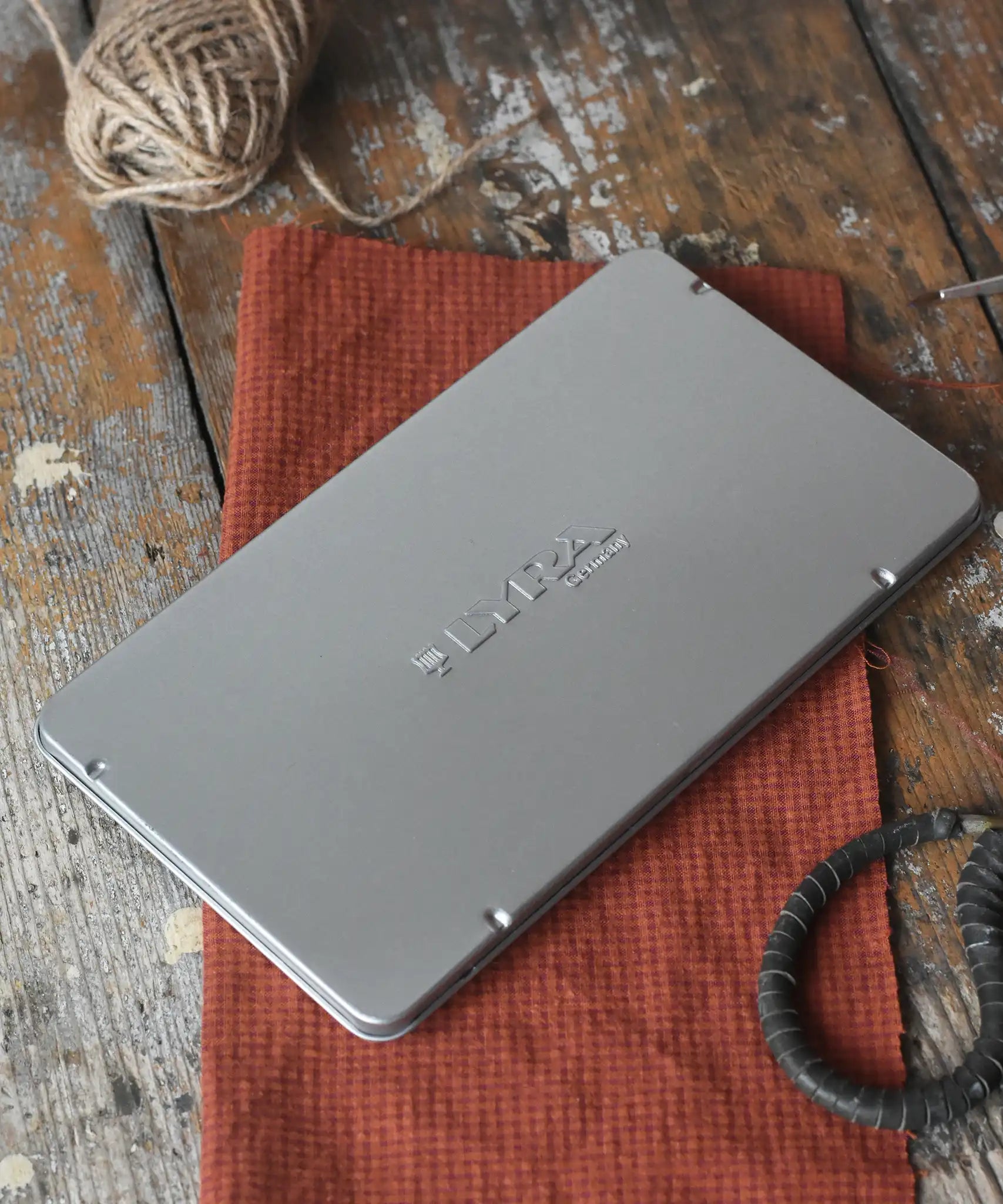 Lyra 12 drawing pencils in sizes from 6B to 4H in a metal storage tin.