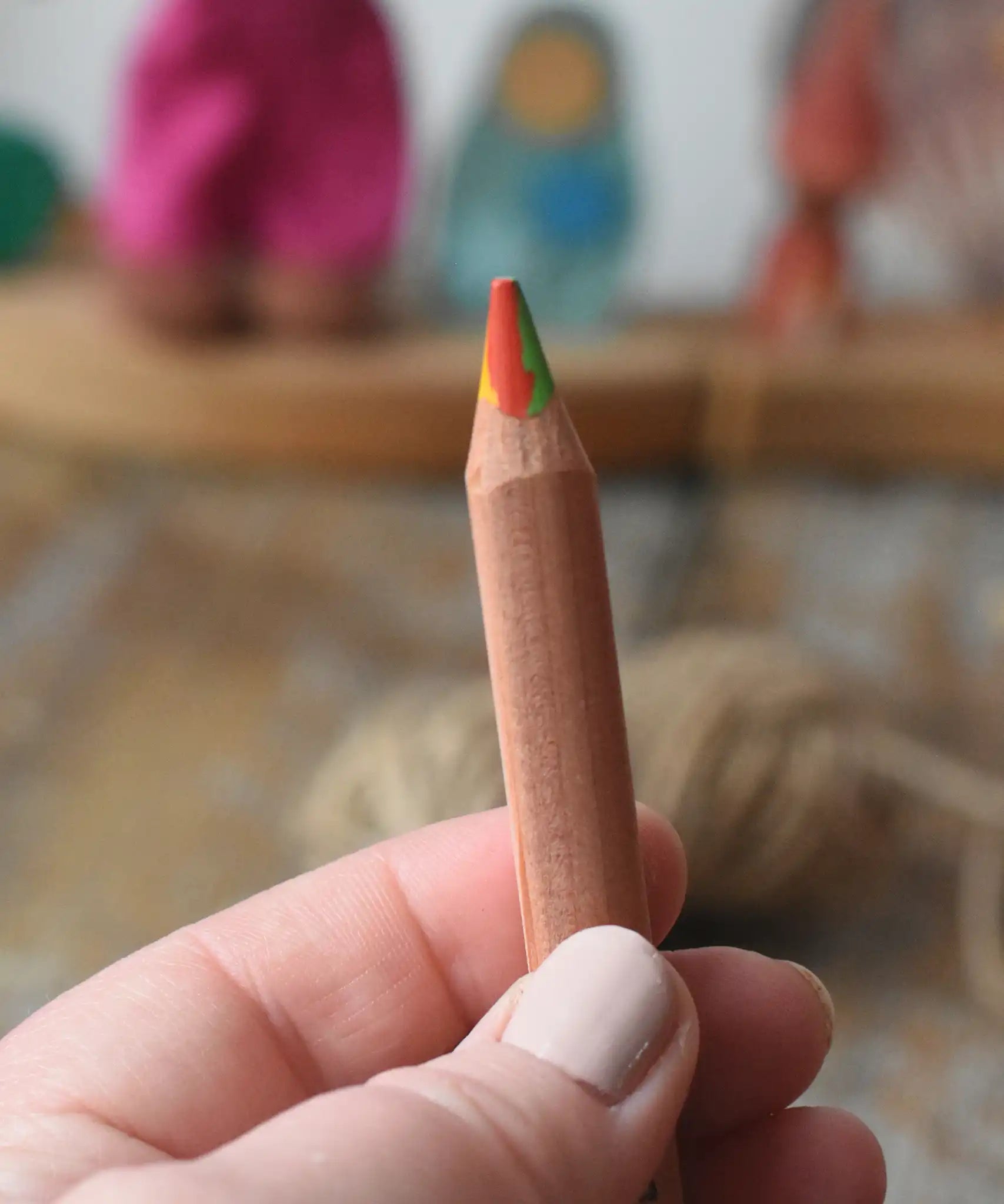 Close up of Lyra super Ferby 4 colour triangular rainbow pencil in an adult's hand.