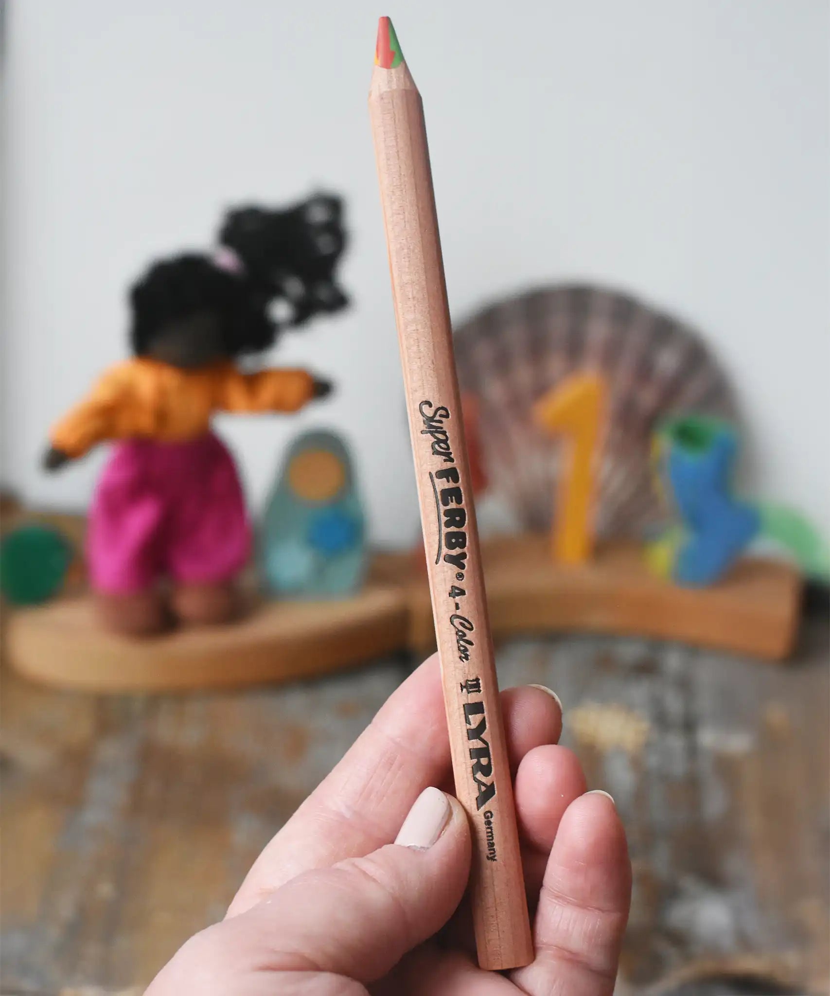 Lyra super Ferby 4 colour triangular rainbow pencil in an adult's hand.