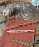 Lyra Ferby triangular shaped graphite HB pencil and rainbow 4 colour pencil placed on a desk.