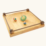 Wooden spinning tops placed on the Mader Kreiselmanufaktur Manège wooden spinning plate.