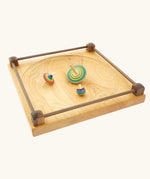 Wooden spinning tops placed on the Mader Kreiselmanufaktur Manège wooden spinning plate.