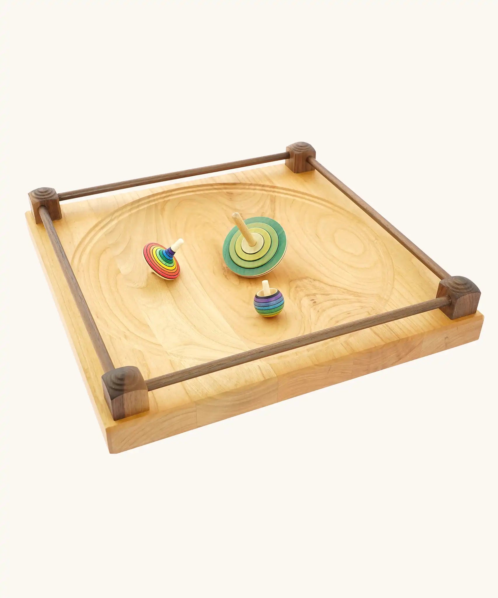 Wooden spinning tops placed on the Mader Kreiselmanufaktur Manège wooden spinning plate.