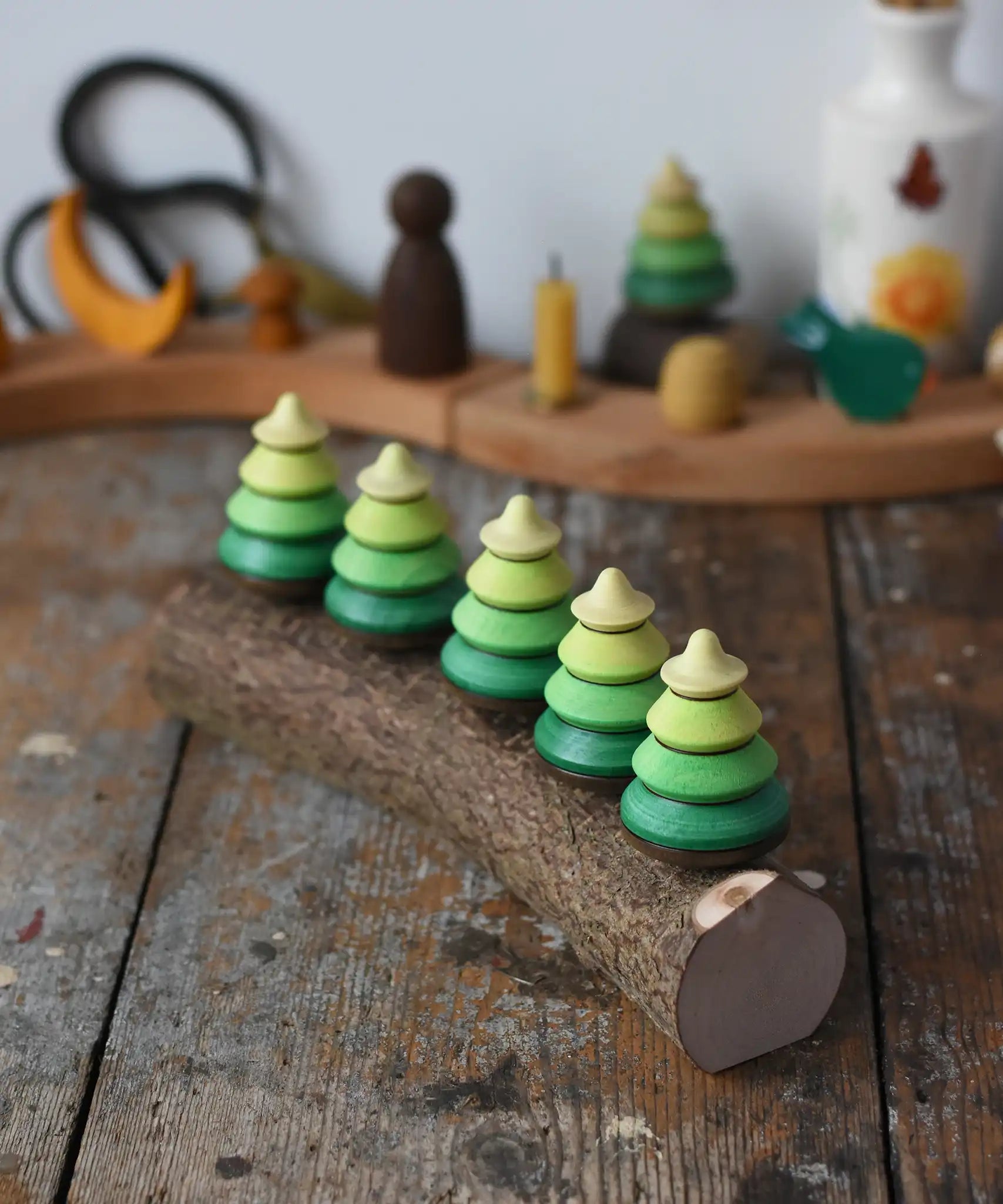 Mader Kreiselmanufaktur 5 tree spinning tops on branch placed on a wooden desk in the Babipur playroom.