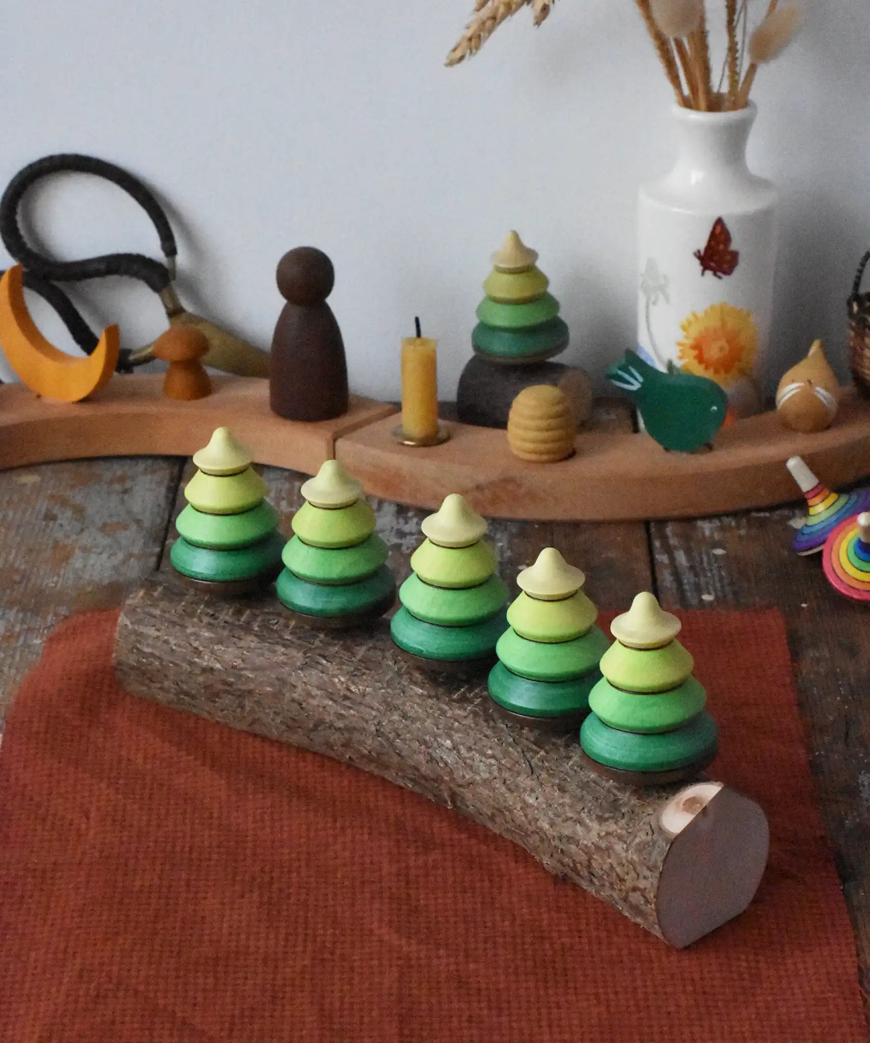 Mader Kreiselmanufaktur 5 tree spinning tops on branch placed on a wooden desk in the Babipur playroom.
