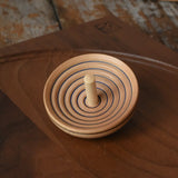 Mader UFO campanola spinning top in blue placed on a walnut spinning plate in the Babipur playroom. 