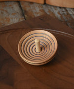 Mader UFO campanola spinning top in blue placed on a walnut spinning plate in the Babipur playroom. 