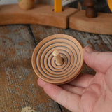 Mader UFO campanola spinning top in blue in an adult hand. 