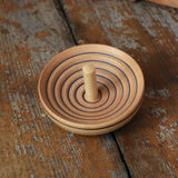 Mader UFO campanola spinning top in blue placed on a wooden desk in the Babipur playroom. 